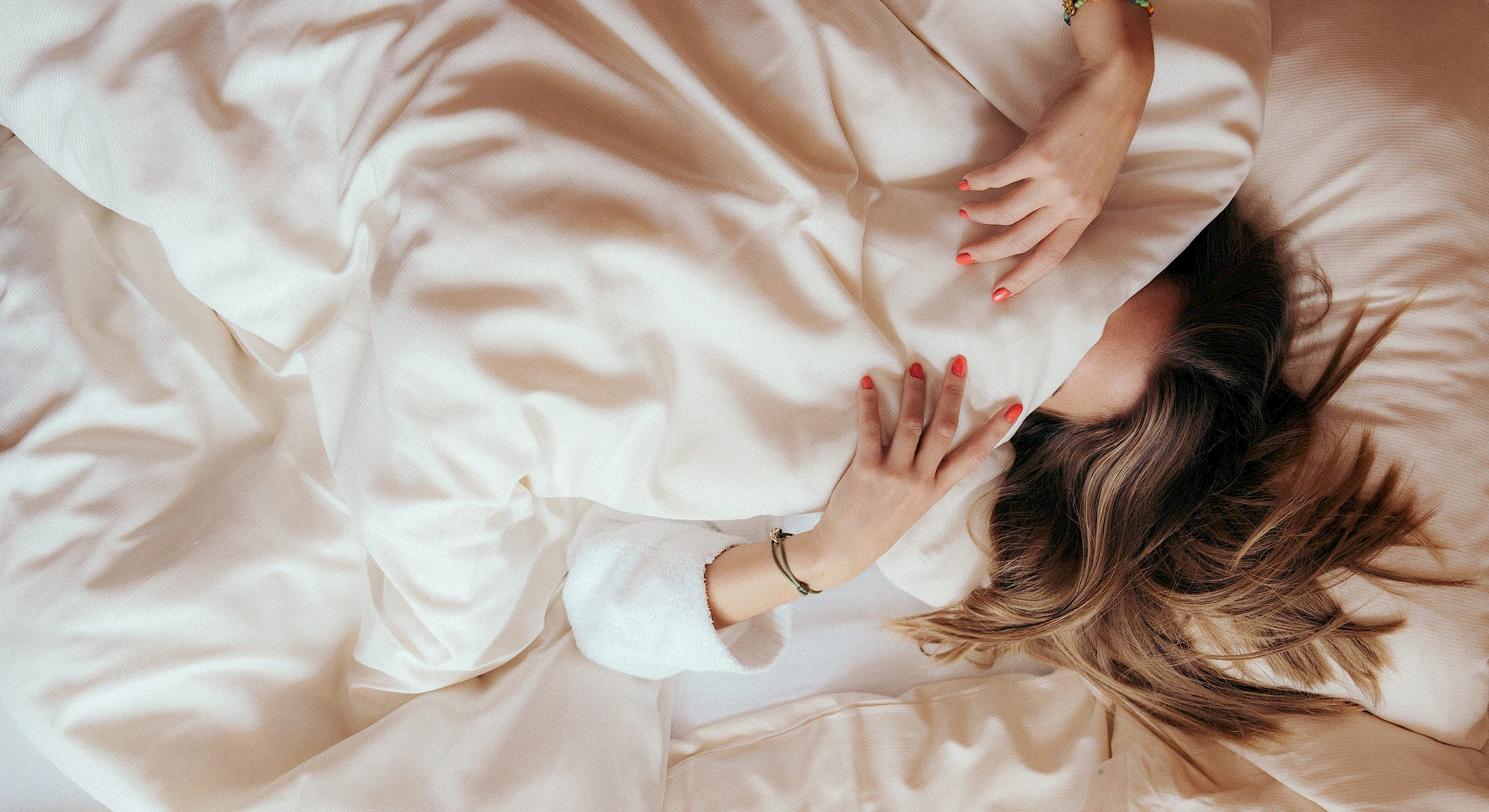 Woman in cosy bed at Schlierseer Hof