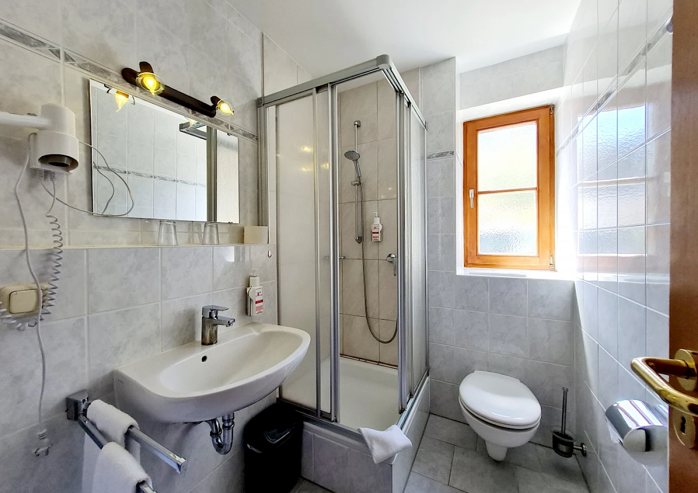 View from above of the shore of Lake Schliersee and the apartment building ‘Kuh am See’